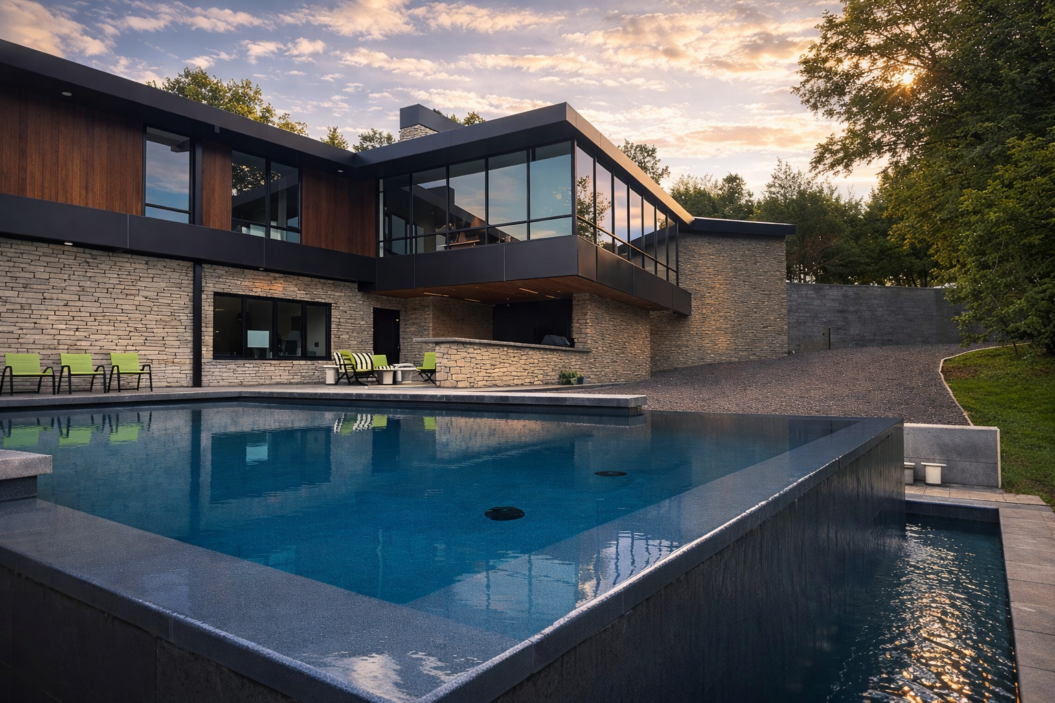 Infinity edge pool at dusk behind a modern stone and wood home — an All3 Pools build